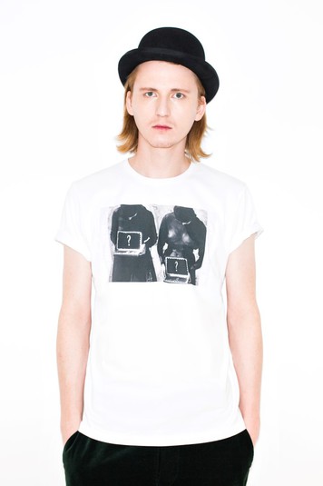 Артём Климчук в футболке Евгении Белорусец. Принт Евгении Белорусец основан на кадре из фильма Александра Медведкина «Счастье» – загадочном, запрещённом, исключительном для советского сталинского кинематографа 1934 года. Изображение позволяет ощутить, как различные миры и реальности встречаются в одном кадре. Что может защитить нас – суеверие или нечто материальное? Принт не укладывается в рамки любой нормы (гетеронормативности, гомосексуальности), но все же повествует о сексуальности, опасности и защите.