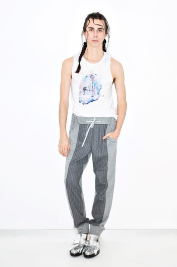 Жан Грицфельд в футболке Kinder Album. На принте Kinder Album изображена женщина, поднимающая над головой презерватив на флагштоке. Она это делает так же, как поднимают свои флаги государства во время торжественных событий. Только в данном случае этот ритуал проводится в честь отношений, любви, секса.