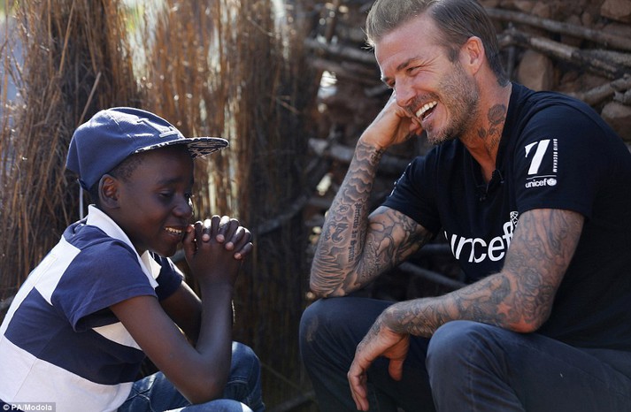 David Beckham brought joy to villagers in Swaziland on a visit to the drought-hit region where his charity work is saving hundreds of lives. He is pictured talking to 14-year-old Sebenelle
