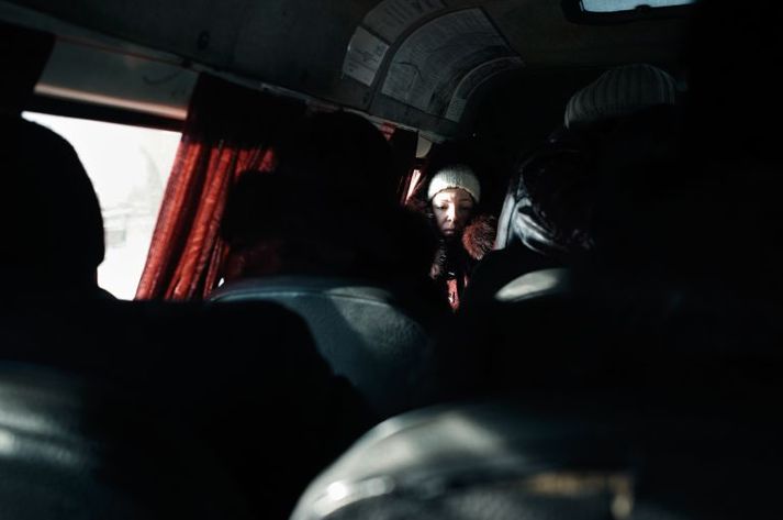 During an early morning rush hour in a Donetsk suburb in 2011, a commuter bus stops next to a tuberculosis clinic whose patients are mostly HIV-positive. Ukraine, 2011.