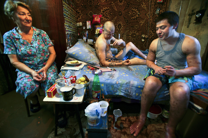 Полтава, 12 августа 2005 г. Живущие на окраине Полтавы, два брата Дима (слева) и Руслан (справа) готовятся уколоть наркотик, пока их мама беспомощно наблюдает за ними. Они наркозависимы уже более двадцати лет, и у них у обоих уже есть дети. Их мать потеряла мужа 15 лет назад и вынуждена была уволиться из садика, где она работала воспитательницей, чтобы присматривать за своими сыновьями, которые употребляют наркотики. Руслан, младший сын, часто ругает ее за то, что она плохая мать, заставляя ее ухаживать за ним и его братом. Ходят слухи, что семья продает наркотики, чтобы братья могли заработать на дозу.