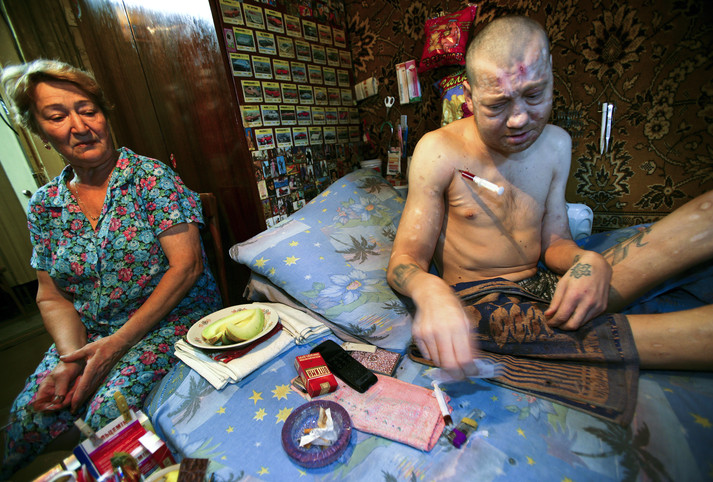 Полтава, 12 августа 2005 г. Живущие на окраине Полтавы, два брата Дима (слева) и Руслан (справа) готовятся уколоть наркотик, пока их мама беспомощно наблюдает за ними. Они наркозависимы уже более двадцати лет, и у них у обоих уже есть дети. Их мать потеряла мужа 15 лет назад и вынуждена была уволиться из садика, где она работала воспитательницей, чтобы присматривать за своими сыновьями, которые употребляют наркотики. Руслан, младший сын, часто ругает ее за то, что она плохая мать, заставляя ее ухаживать за ним и его братом. Ходят слухи, что семья продает наркотики, чтобы братья могли заработать на дозу.