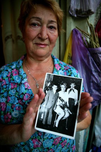 Полтава, 12 августа 2005 г. Живущие на окраине Полтавы, два брата Дима (слева) и Руслан (справа) готовятся уколоть наркотик, пока их мама беспомощно наблюдает за ними. Они наркозависимы уже более двадцати лет, и у них у обоих уже есть дети. Их мать потеряла мужа 15 лет назад и вынуждена была уволиться из садика, где она работала воспитательницей, чтобы присматривать за своими сыновьями, которые употребляют наркотики. Руслан, младший сын, часто ругает ее за то, что она плохая мать, заставляя ее ухаживать за ним и его братом. Ходят слухи, что семья продает наркотики, чтобы братья могли заработать на дозу.