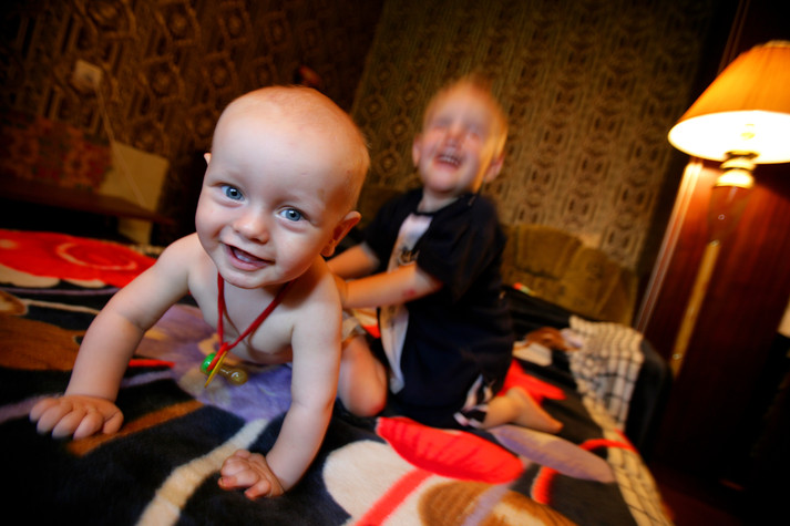 Одесса, 19 августа 2005 г.
Филипп (сидит на колене своего отца) родился 11 месяцев назад как от ВИЧ-позитивной матери. Его статус пока не подтвержден. С Пети, его двухлетнего брата, уже сняли ВИЧ-позитивный статус после повторного отрицательного теста. Их родители, Таня и Сергей – бывшие потребители инъекционных наркотиков, оба ВИЧ-позитивные люди. Они стали очень религиозными и в данный момент не принимают антиретровирусную терапию, глубоко веруя в Божье провидение.