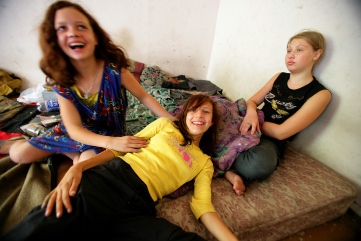 Одесса, 21 августа 2005 г.
Три девочки, которые живут в заброшенном доме. Сотрудники местной неправительственной организации «Дорога к дому» пытаются навещать этих детей регулярно, приносить им еду, презервативы и чистые шприцы. В Одессе насчитывается более 5 000 уличных детей. Из-за их опыта жизни на улице они не говорят на общепринятом в обществе языке. Из них в Украине формируется криминальный слой. Старшие преступники часто используют их для воровства, потому что по возрасту их труднее привлечь к ответственности. Девочек часто заставляют заниматься коммерческим сексом, они подвергаются насилию, часто страдают от заболеваний, передающихся половым путем, часто беременеют в раннем возрасте. То, что многие из них инфицированы ВИЧ и потребляют инъекционные наркотики, только добавляет им отчаяния и бесстрашия. Пренебрежение к проблемам уличных детей и ВИЧ-инфекции станет огромной проблемой для Украины в будущем.