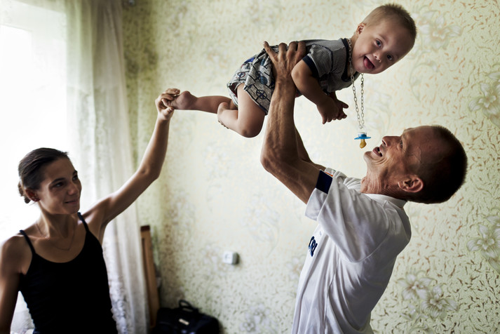 Кривой Рог, Днепропетровская область, август 2011.
Олег (ВИЧ-позитивный, употребляет наркотики; у него всего 20 клеток CD4 при норме от 700 до 1 500) с сыном и женой. Олег понимает, что скоро умрет, поэтому совсем недавно он официально оформил отношения со своей девушкой и матерью своего сына, чтобы после его смерти у жены и ребенка были права на его имущество. Одна из причин того, что он не может поддерживать свое здоровье, – отсутствие доступа к препаратам антиретровирусной терапии. Из-за непроведенных вовремя тендеров по закупке препаратов многие пациенты умирают, не получая доступа к лекарствам, жизненно важным для поддержания их здоровья. Жена ВИЧ-отрицательная и не употребляет наркотики. У ребенка какое-то неврологическое заболевание, явная проблема в развитии.