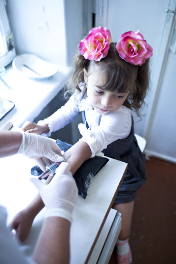 Донецкая область, сентябрь 2011.
Алина, 10 лет, ВИЧ-позитивная. Алину осматривают и делают ей тесты врачи мобильной клиники, которая приезжает в маленькие населенные пункты Донецкой области и оказывает услуги ВИЧ-позитивным детям региона в рамках проекта Фонда Елены Пинчук «АНТИСПИД». Для них это единственная возможность получить медицинские услуги и доступ к лечению. От врачей мобильной клиники Алина получает препараты антиретровирусной терапии на ближайшие три месяца. Родители Алины – ВИЧ-позитивные наркозависимые люди, большую часть времени она проводит с бабушкой. Алина очень самостоятельная, она сама общается с врачами, обсуждая свое здоровье, и хорошо понимает что происходит. Она сама готовит и убирает, она хорошо воспитана и хорошо учится в школе – удивительно, учитывая социальное окружение и обстоятельства, в которых она находится.